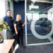 Two Ecoefficient team members stood by the door of their office smiling at the camera